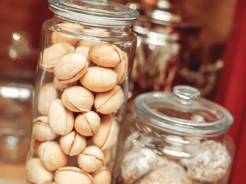 Des bocaux en verre remplis de biscuits maison, posés sur le comptoir.